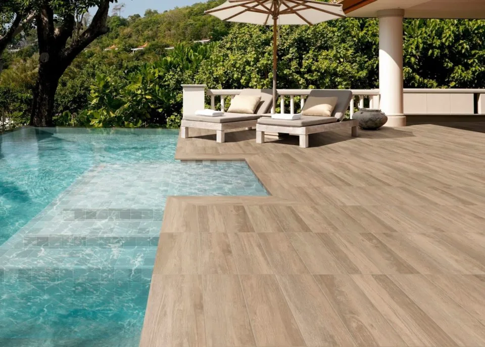 Piscina a medida integrada en una terraza de acabados naturales