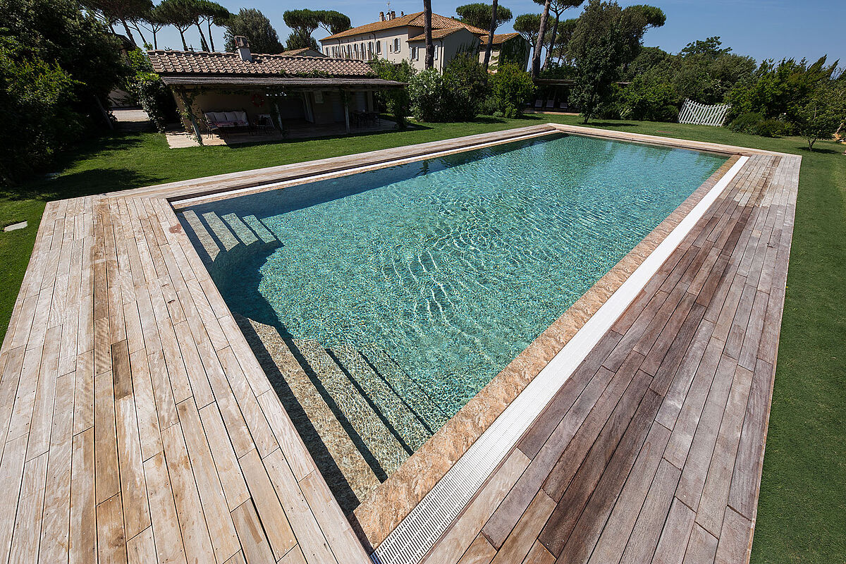 Piscina integrada en un entorno exterior de acabados naturales